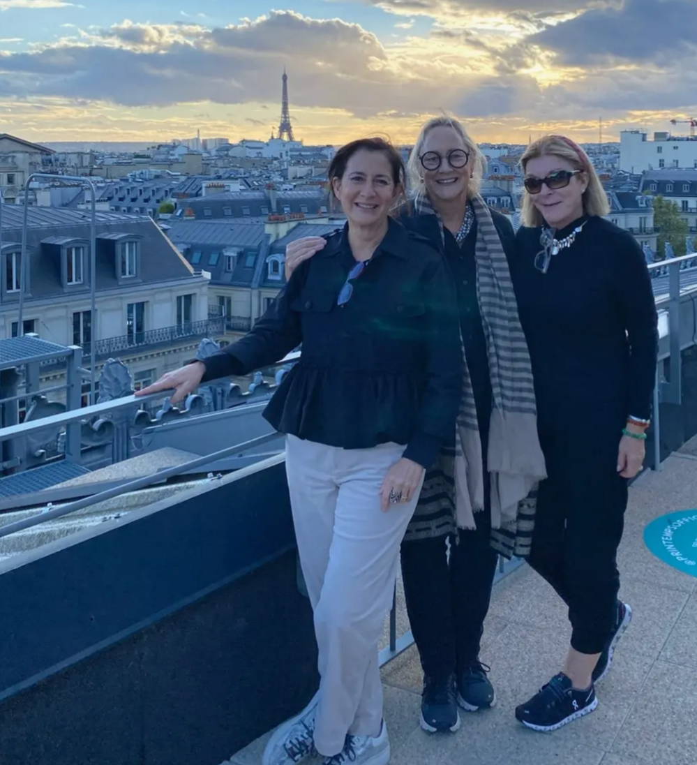 Ann Connelly of Ann Connelly Fine Art, Rebecca Vizard of B. Viz Design and Loika Hodges pose atop a rooftop in front of the Eiffel Tower in Paris, France.