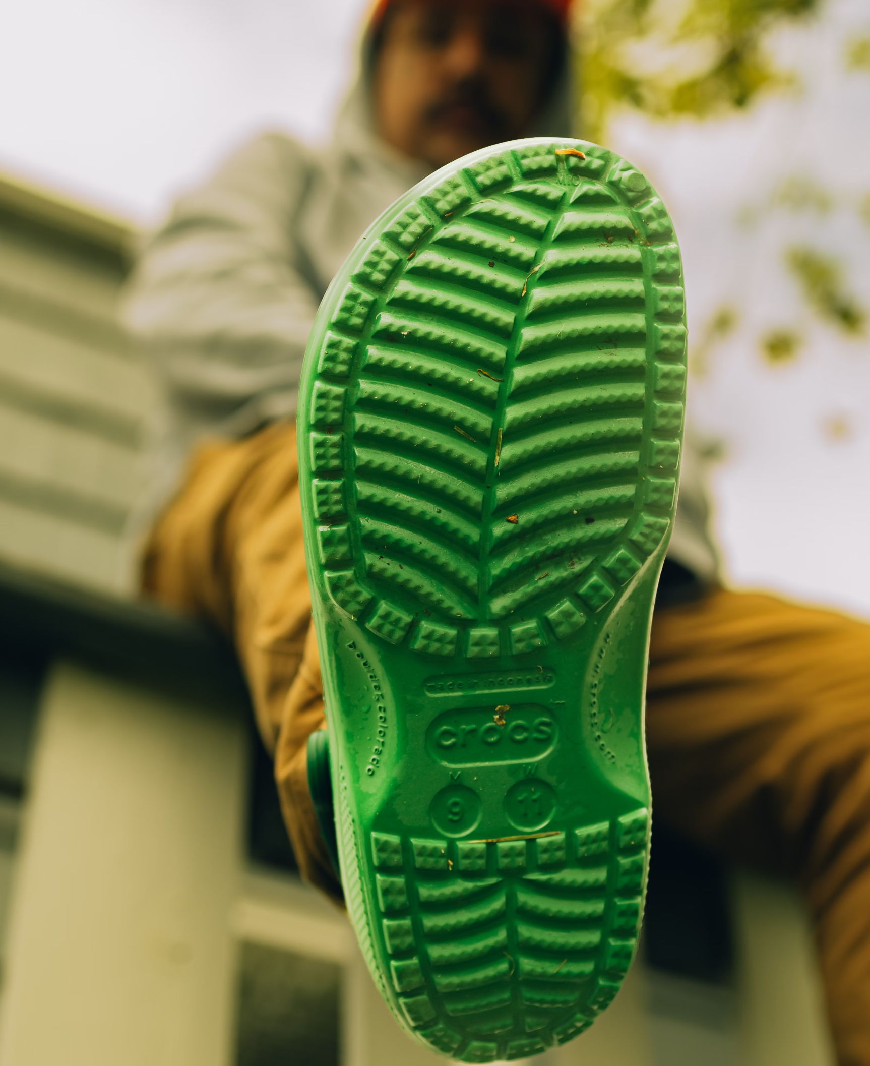 Someone showing off the green sole of their shoe to the camera