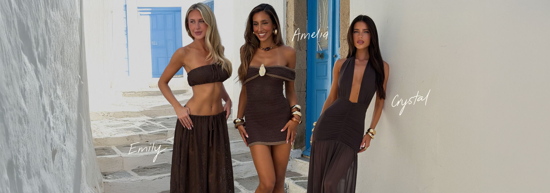 Three women in stylish outfits pose against a white wall.
