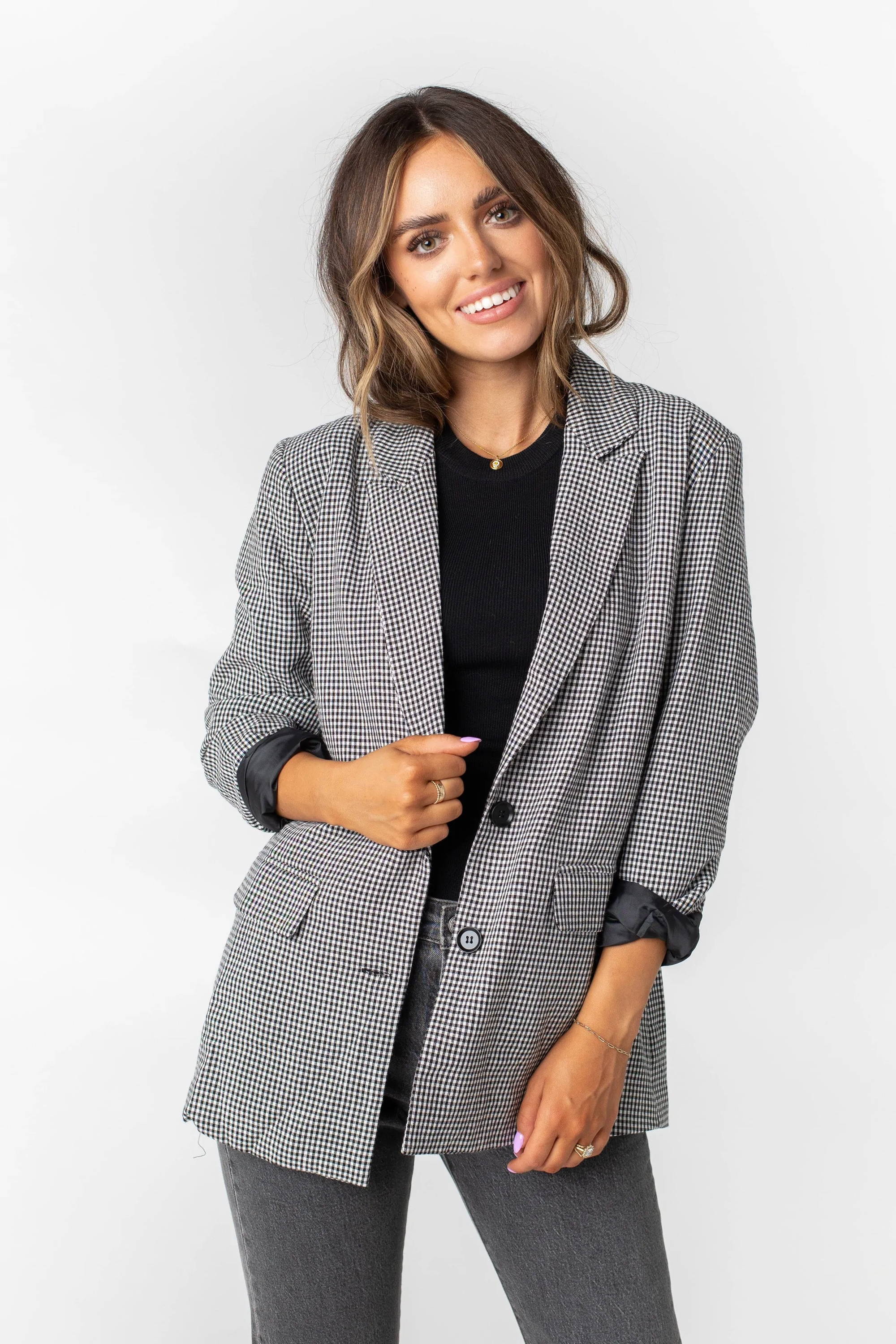 A woman poses in a black and white checkered blazer