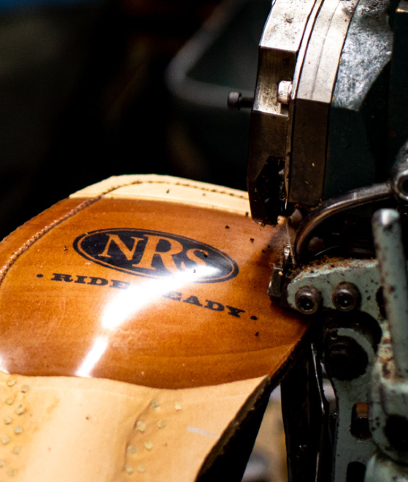 Sewing machine stitching a leather sole on a cowboy boot with NRS branding.