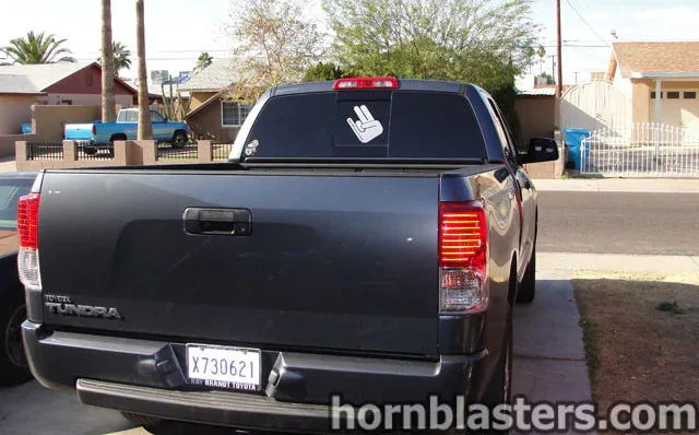 Rear three-quarter dark gray Cody's 2010 Toyota Tundra tailgate chrome emblems shocker hand sticker tinted rear window residential driveway Shocker XL install gallery photo 2