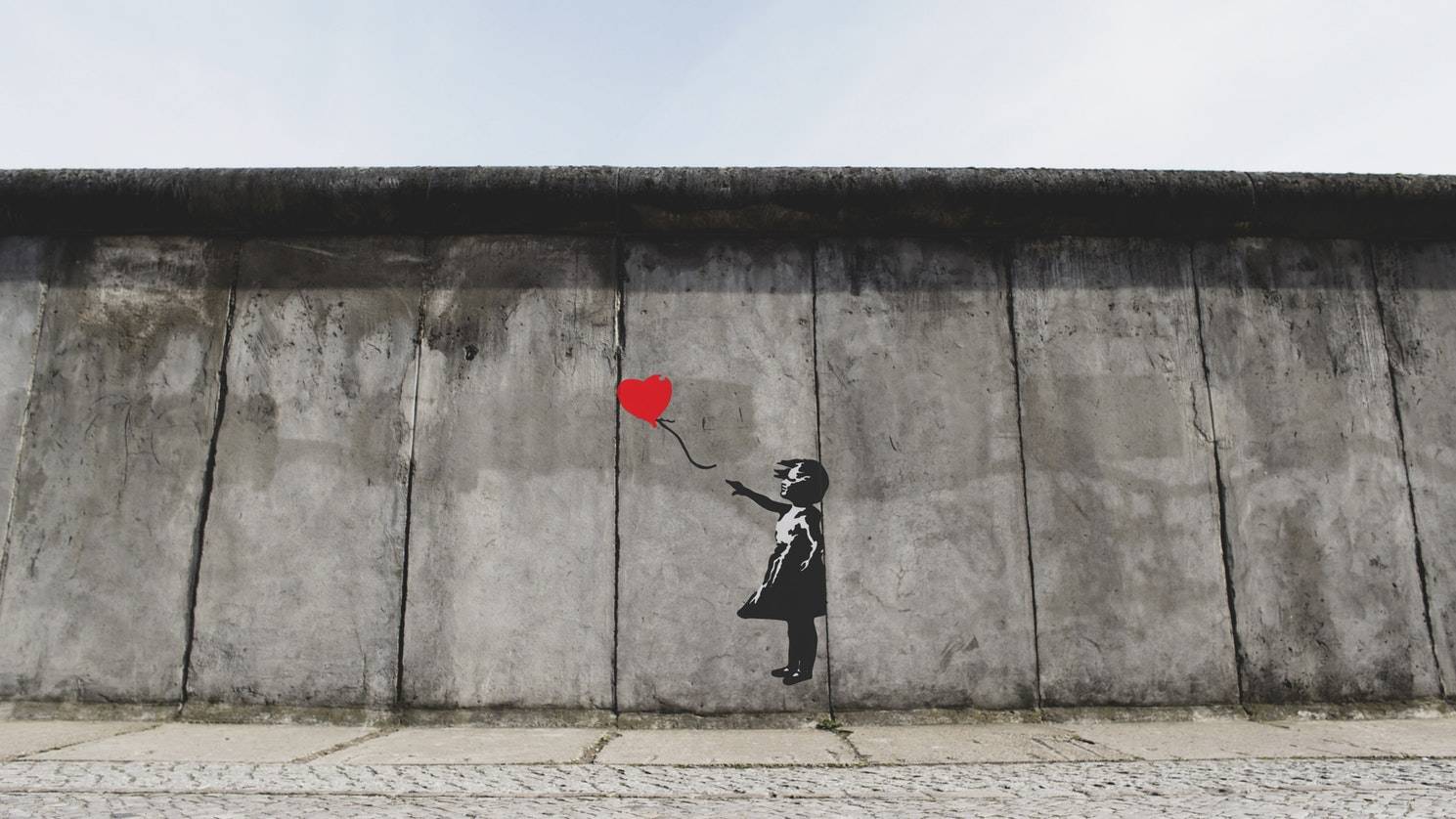 Difference between Decor Art and Fine Art: Banksy. Image of a girl with a red balloon on a concrete wall