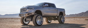 Lifted gray 2019 Dodge Ram 1500 Limited on oversized chrome wheels parked in the desert