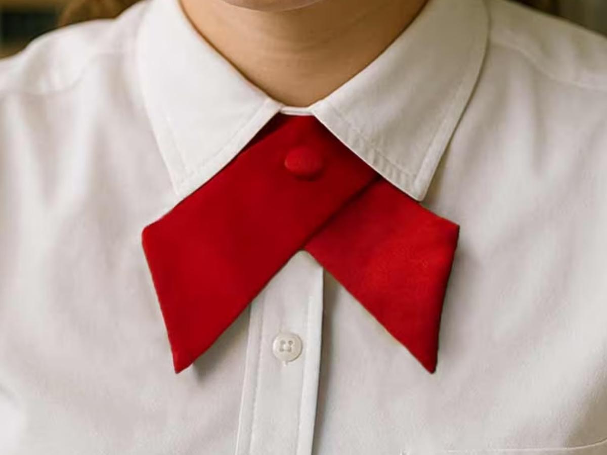 Teen wearing a red crossover tie as part of a school uniform