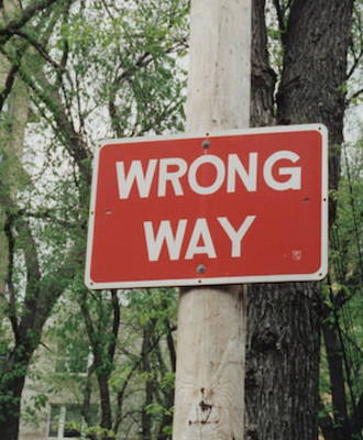 A wrong-way sign alerting oncoming drivers of correct direction.