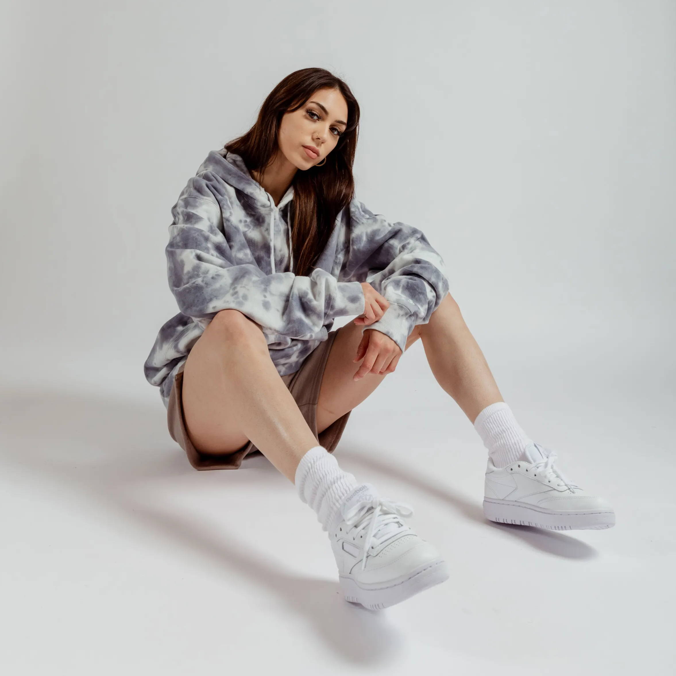 female model wearing gray hoodie and reebok shoes