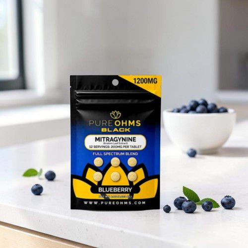 Package of Pure Ohms Black supplements with blueberries on a countertop.
