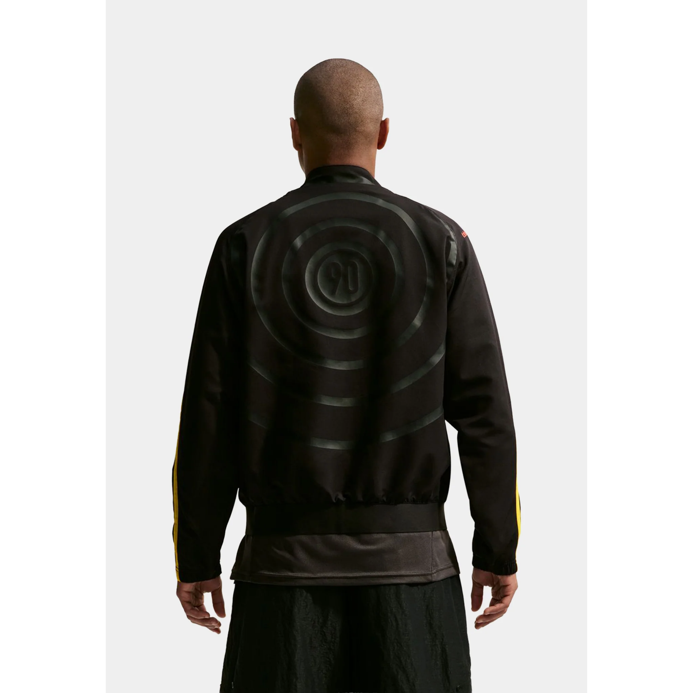 Person wearing a black and yellow Nike jacket.