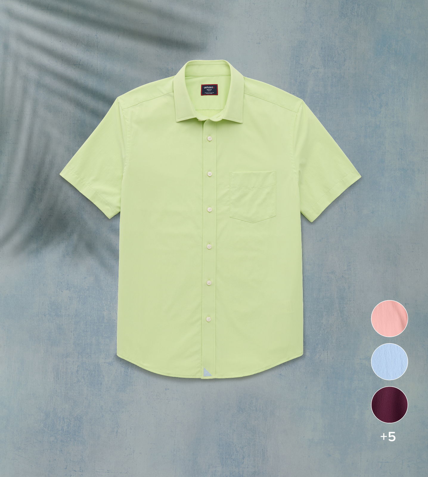 Light green short-sleeve shirt displayed against a textured background with color options.