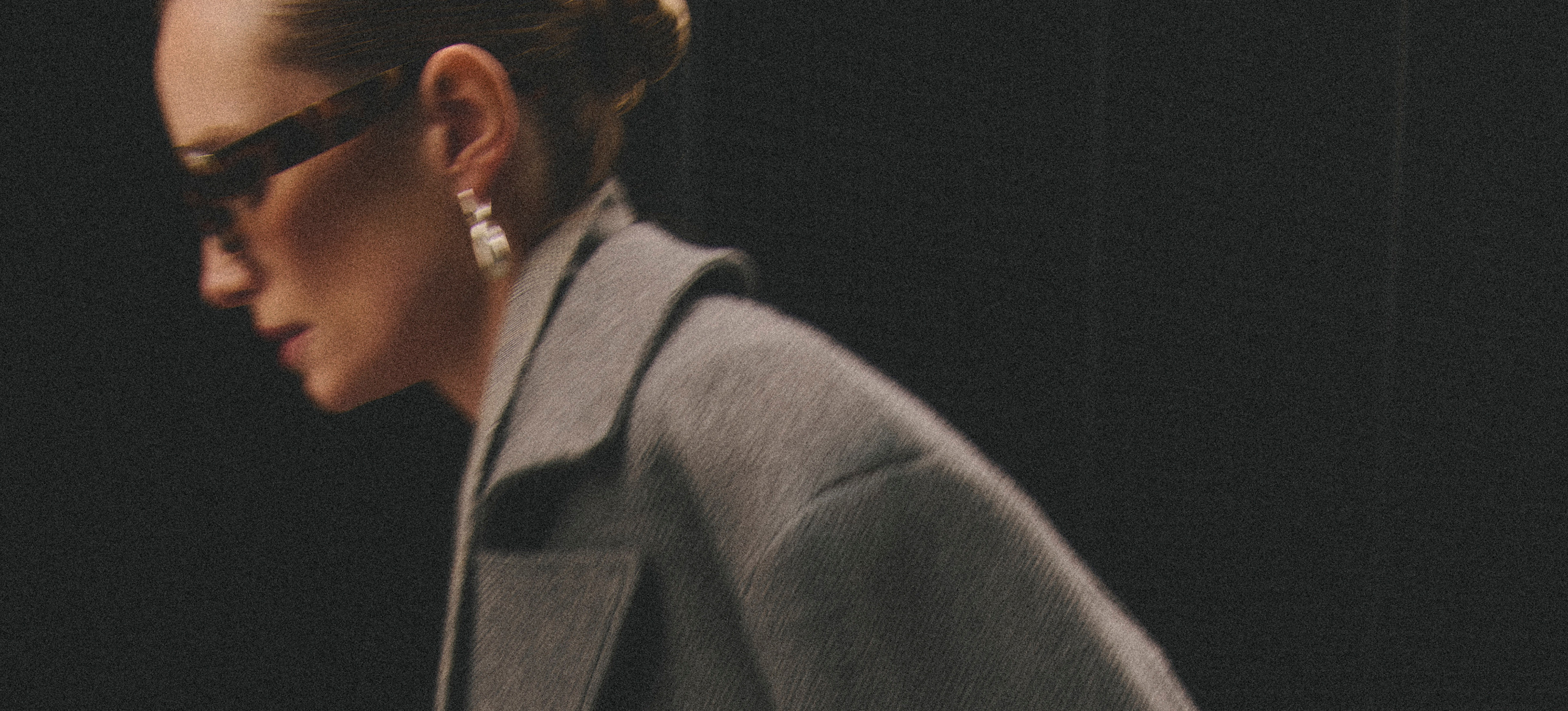 Model wearing grey Tero coat and sunglasses