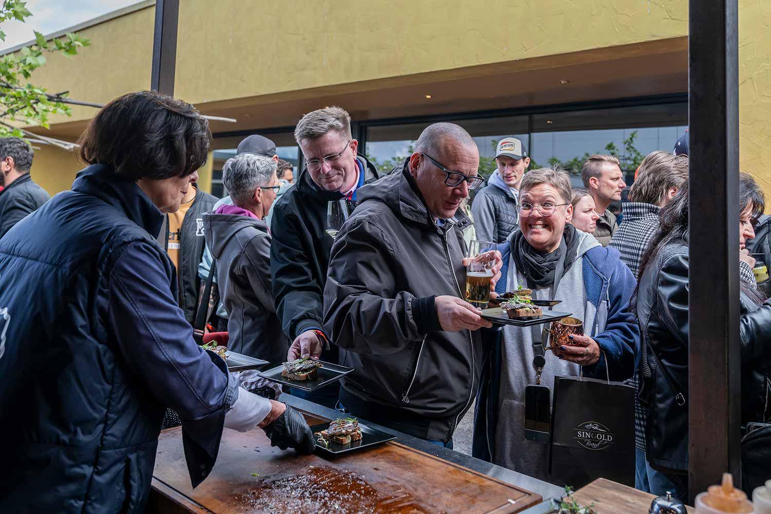 People enjoying food and drinks at an outdoor event.