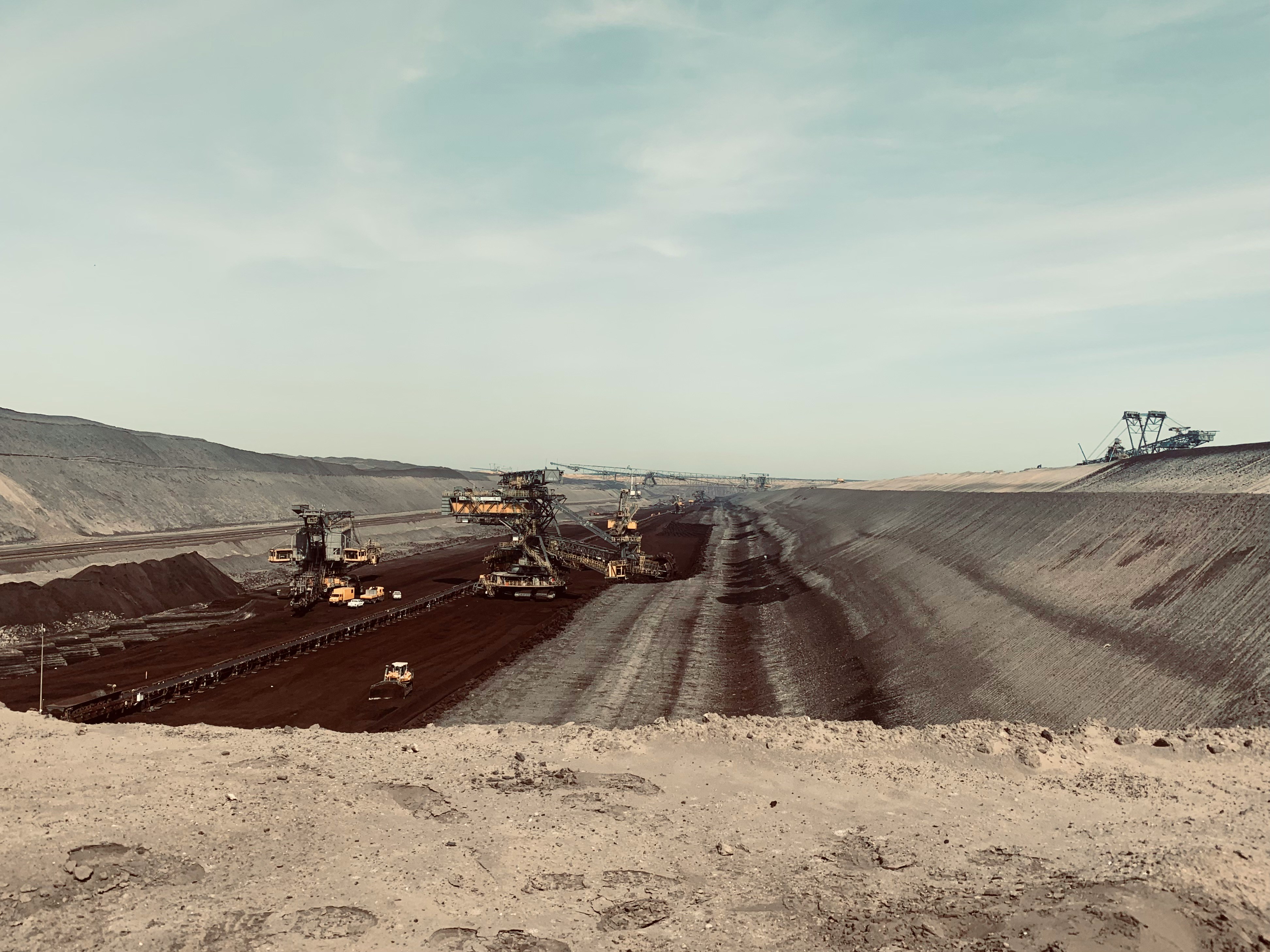 Wide view of large-scale mining machinery operating across active production areas in an open-pit mine