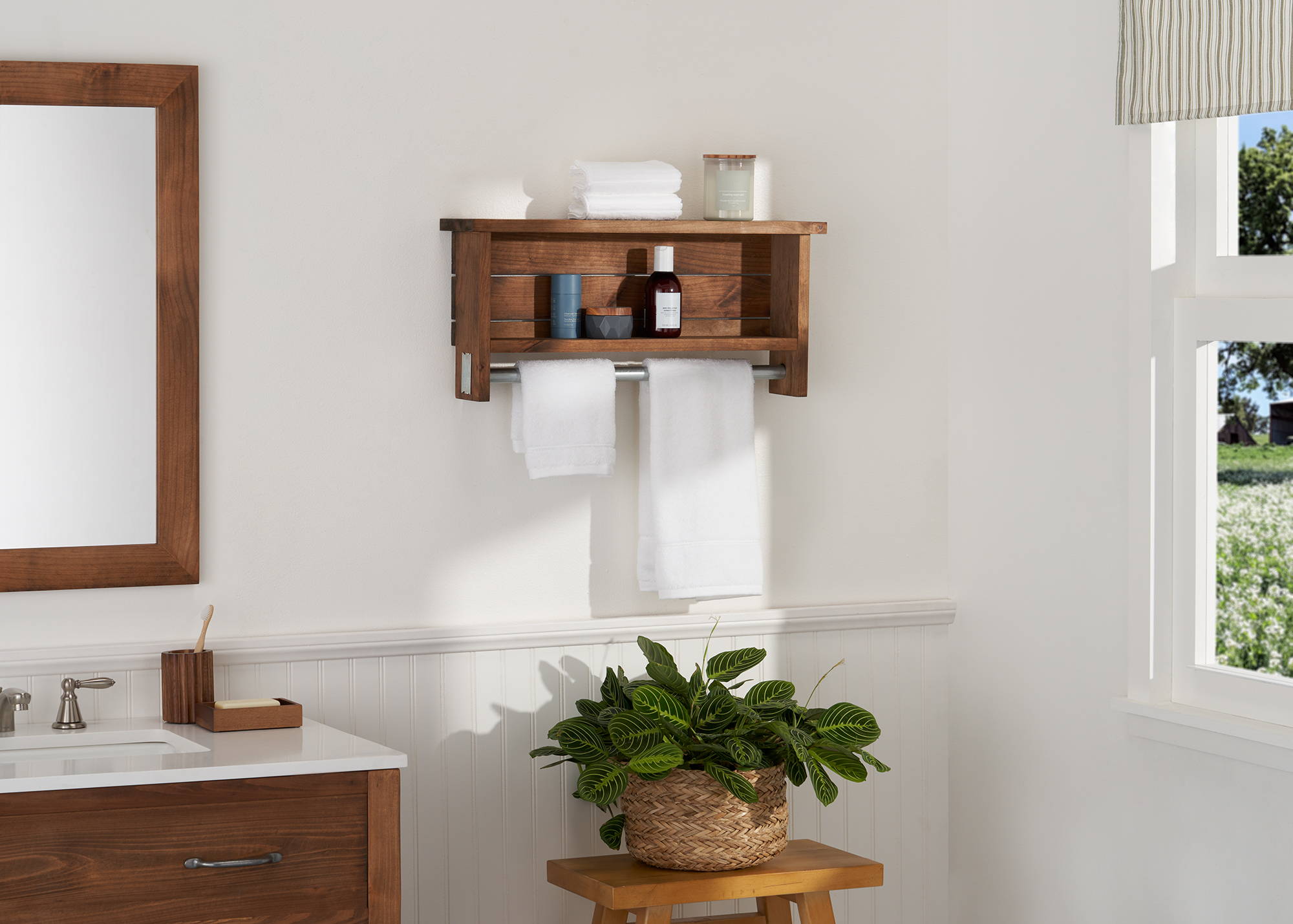 farmhouse style bathroom towel bar with shelves, filled with self care items and two hand towel