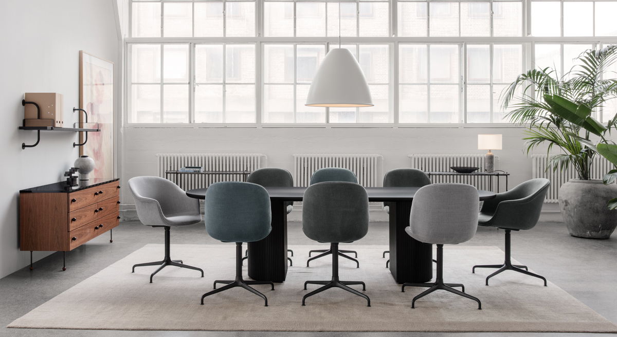 Modern Bat Office Chairs by Gubi conference room with chairs, table, and large windows.
