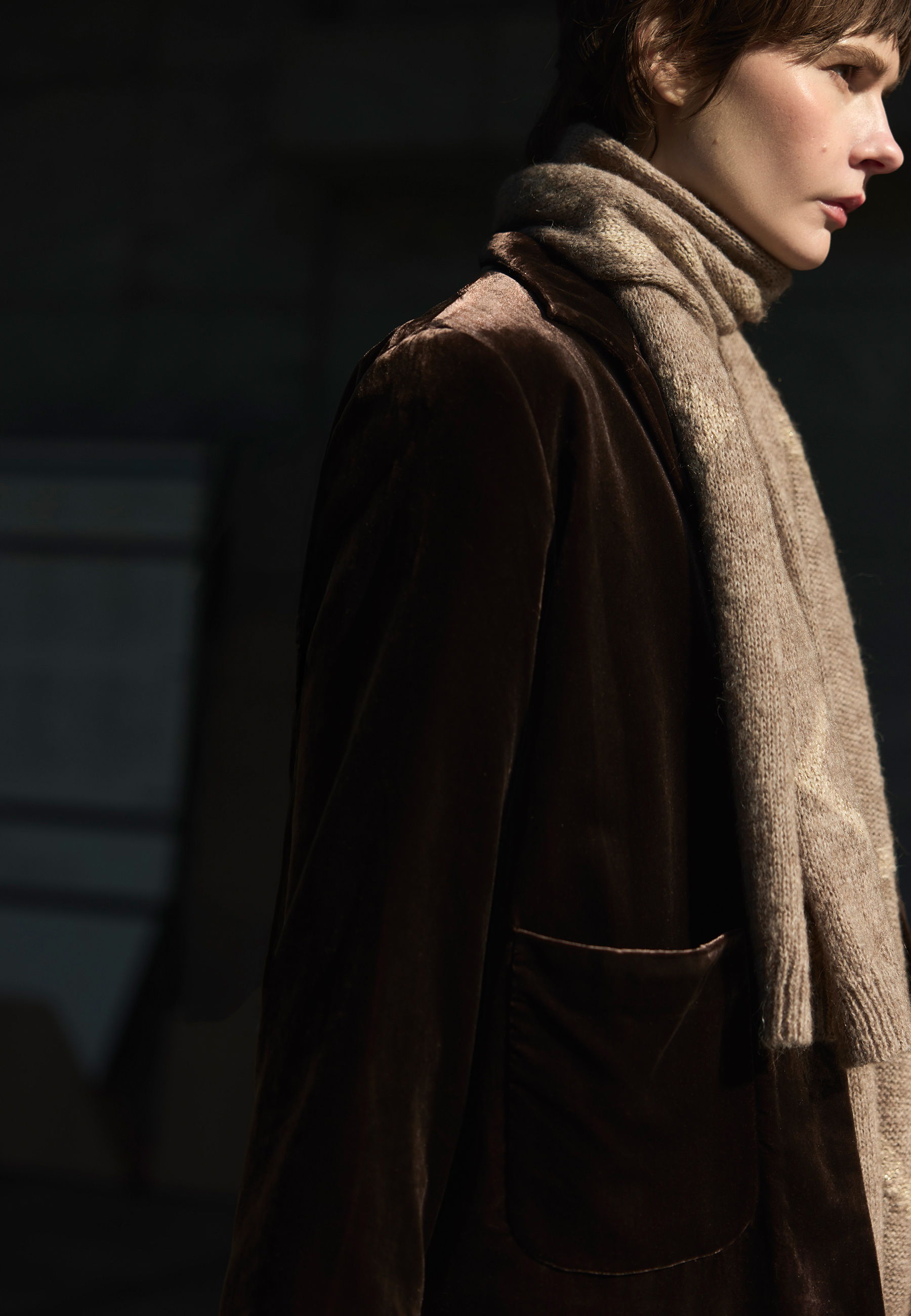 A model in a brown velvet jacket and scarf.