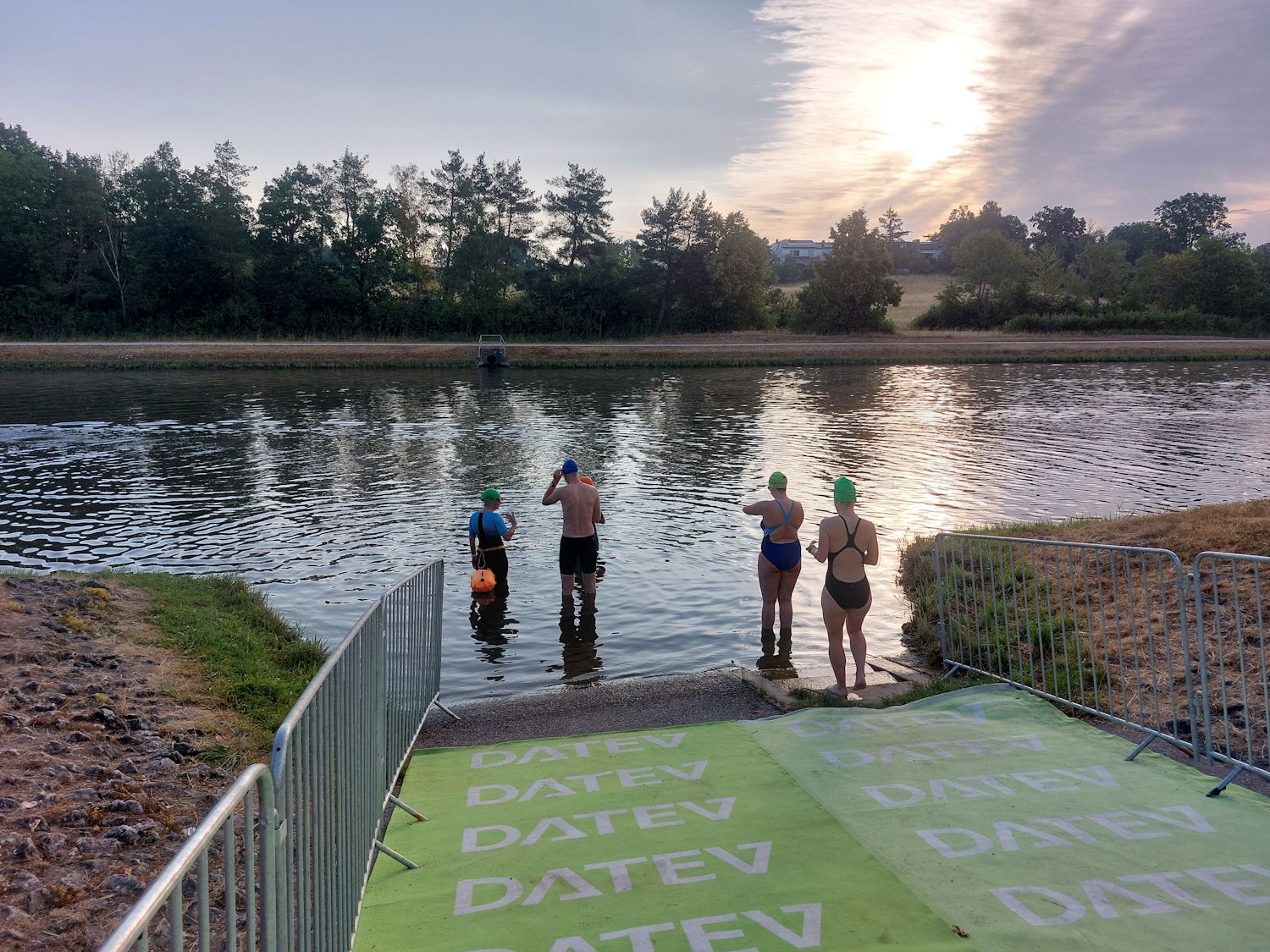 Triathleten beim Wassereinstieg von hinten fotografiert.