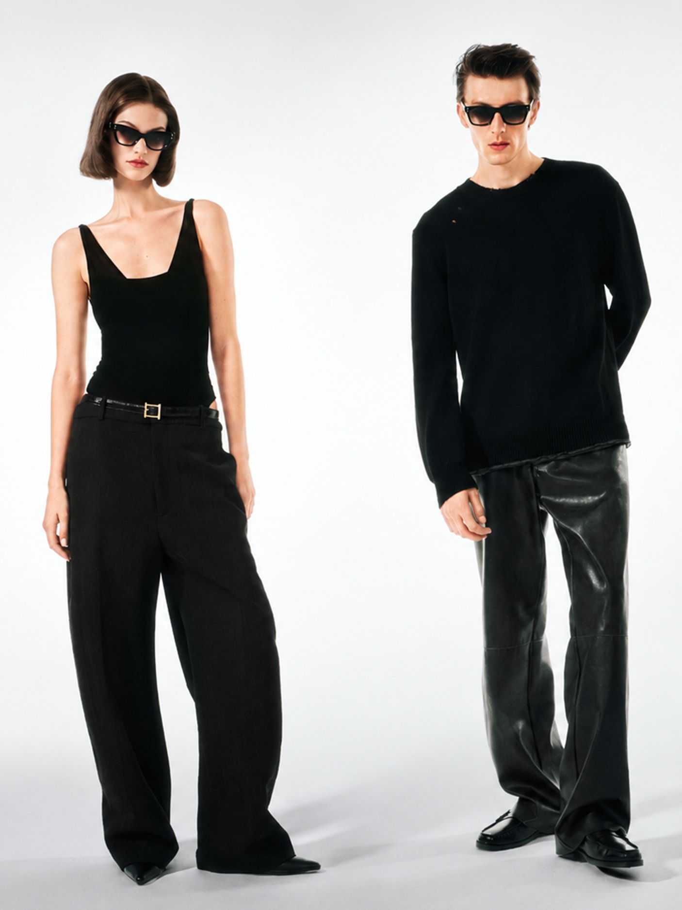 Two models in black outfits wearing Robert Marc sunglasses against a plain background.