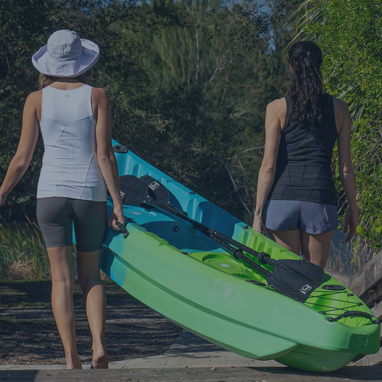 Women carrying a kayak wearing Lower Back Support Tanks