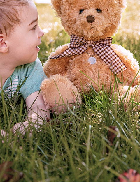 kid sitting with a memorial teddy bear