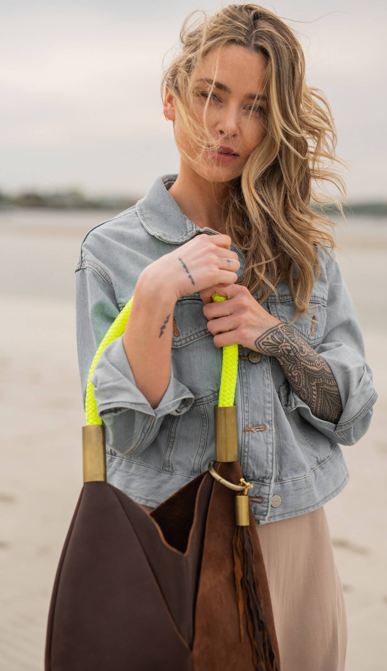 woman wearing brown leather tote with neon yellow dock line