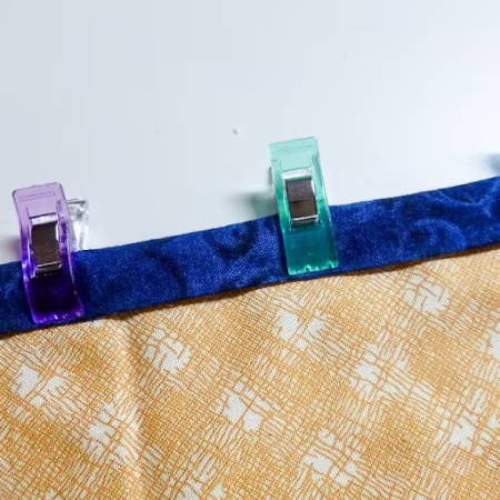 sewing clips to temporarily hold the binding on a quilt
