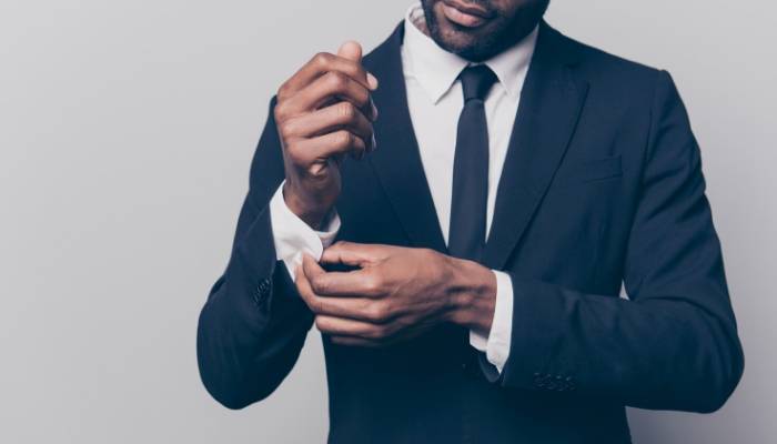 Man in suit and tie adjusting cuffs