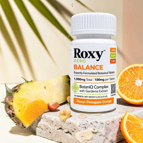Roxy Balance dietary supplement bottle with fruits on a stone surface.