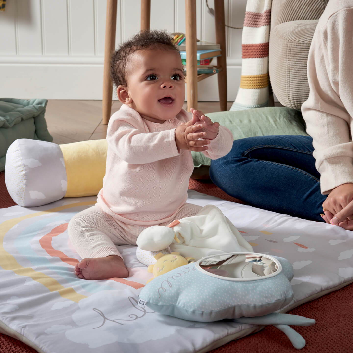 Baby sat clapping on a printed playmat
