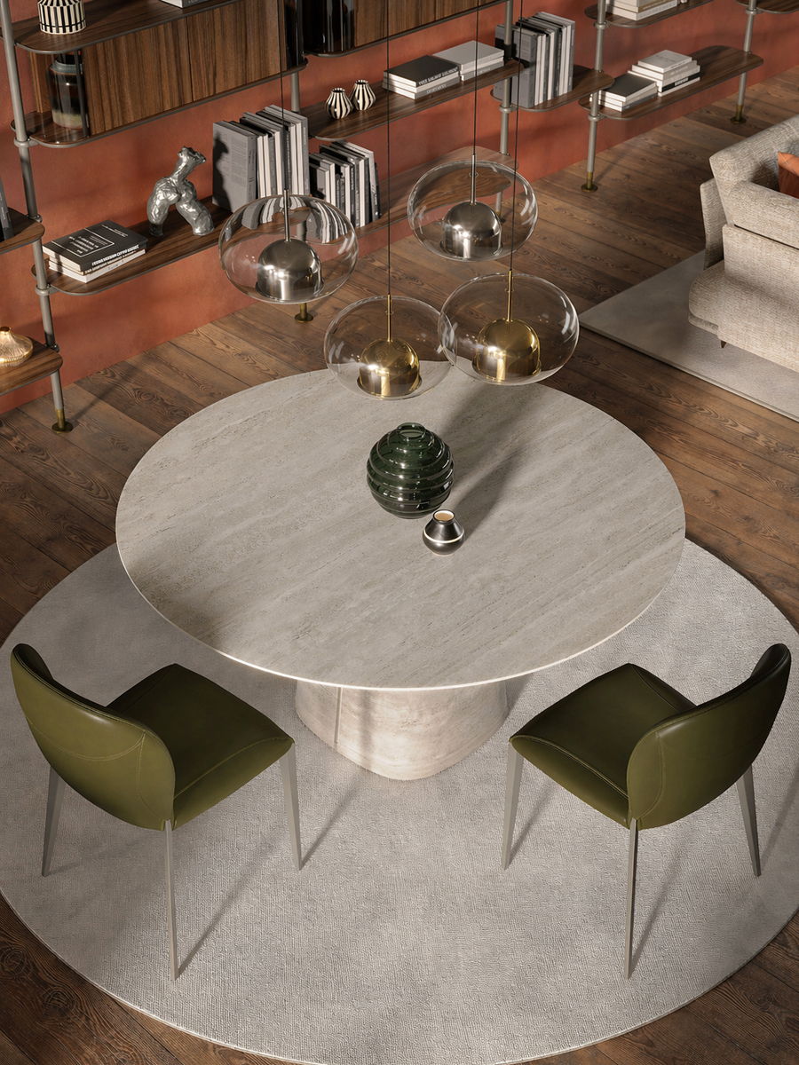 Modern round dining table with green chairs and decorative elements.