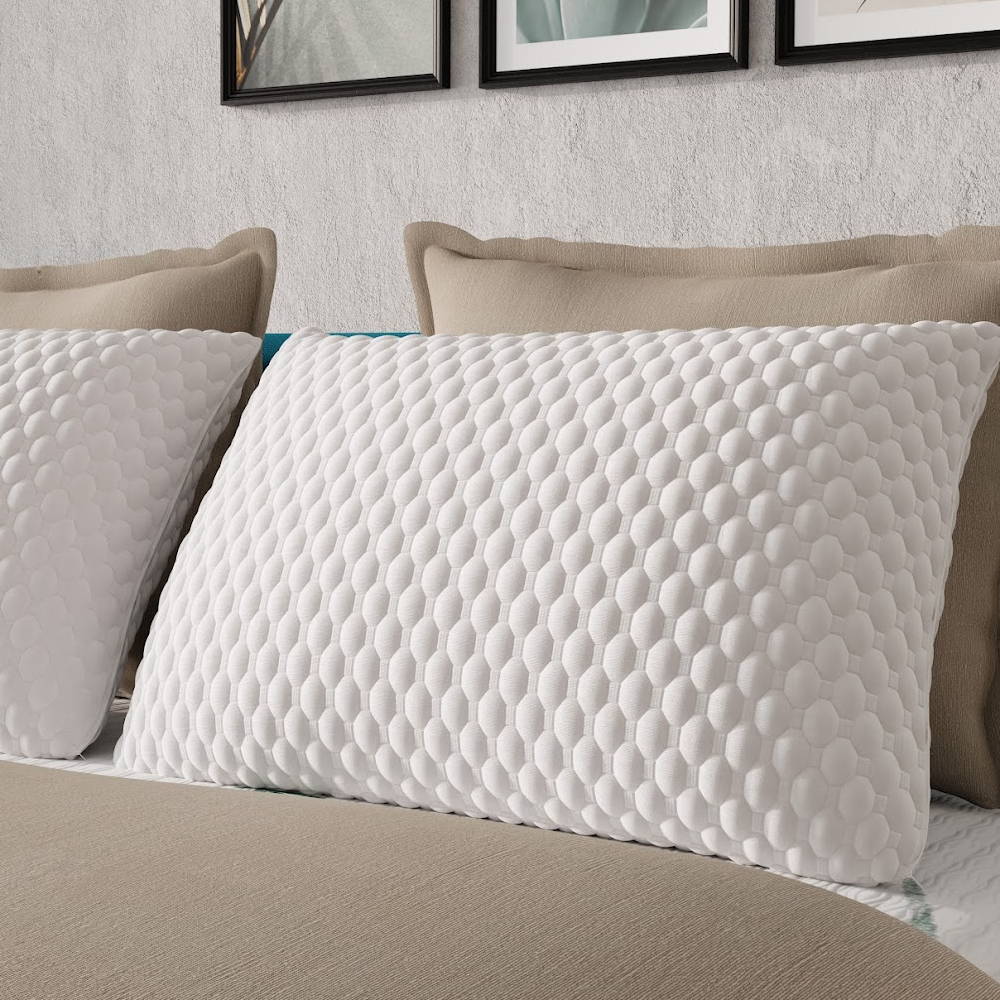 ZenCloud pillows with cbd, copper, and gel infusions sitting on a bed with beige covers, showing the soft quilted white cover. 
