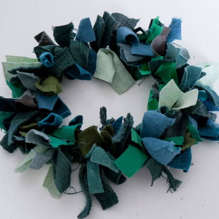 a diy fabric wreath made from scraps in different shades of green