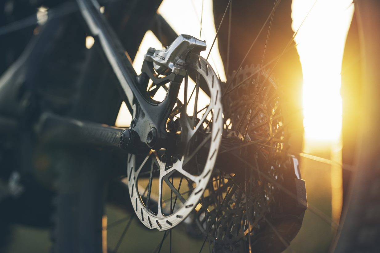 sram code ultimate stealth mountain bike brake caliper in golden hour 