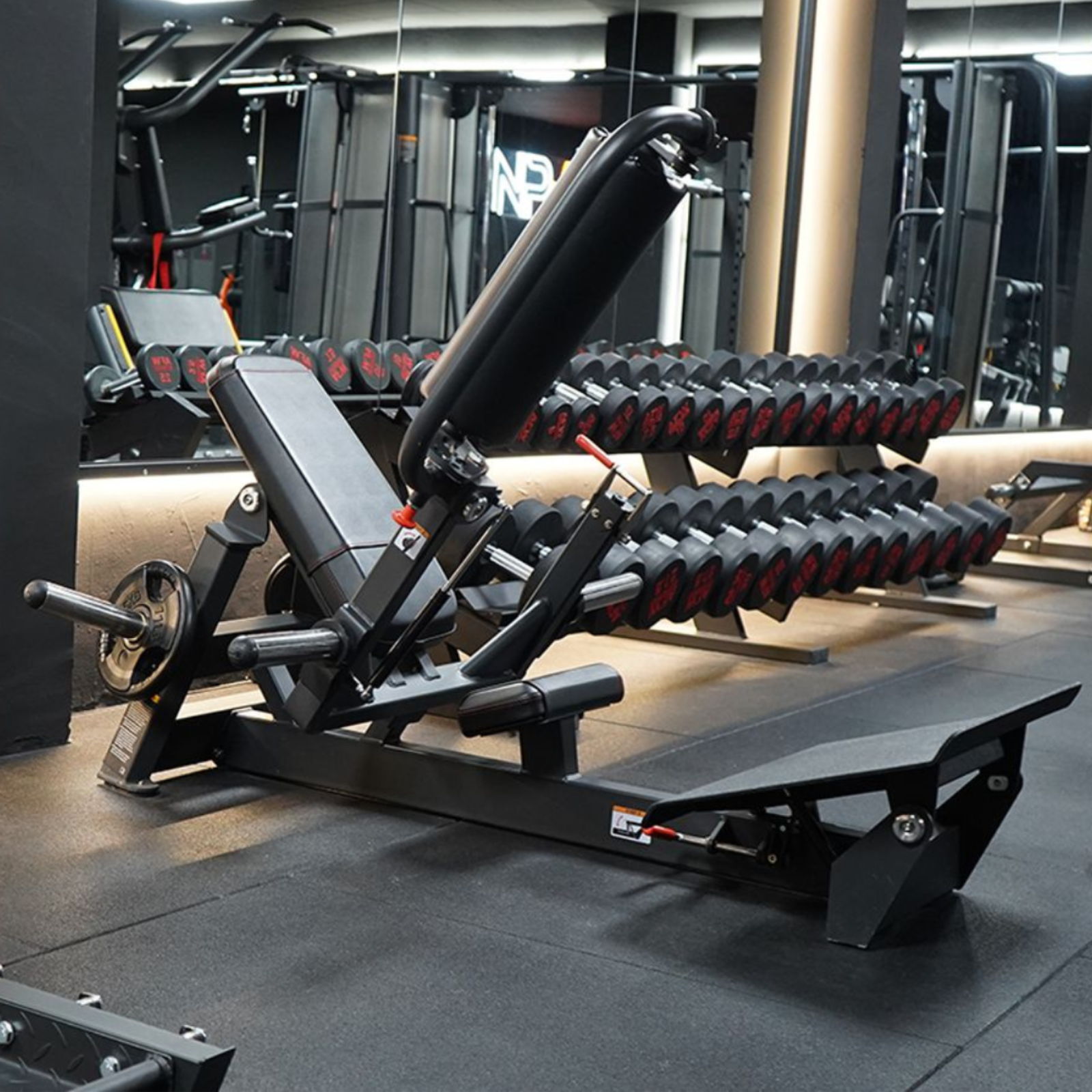 Weightlifting equipment and dumbbells in a modern gym setting.