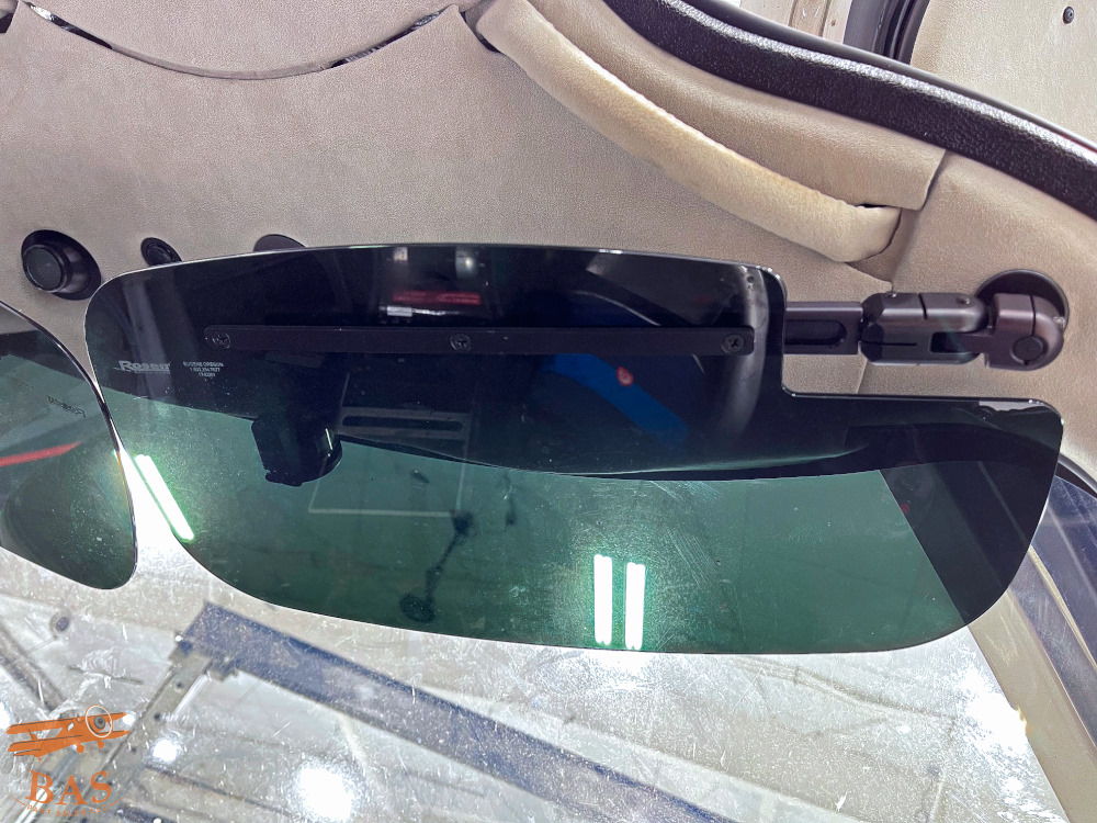 Black sunglasses with a green tint displayed on a surface.