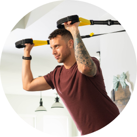 Person exercising with a suspension trainer indoors.