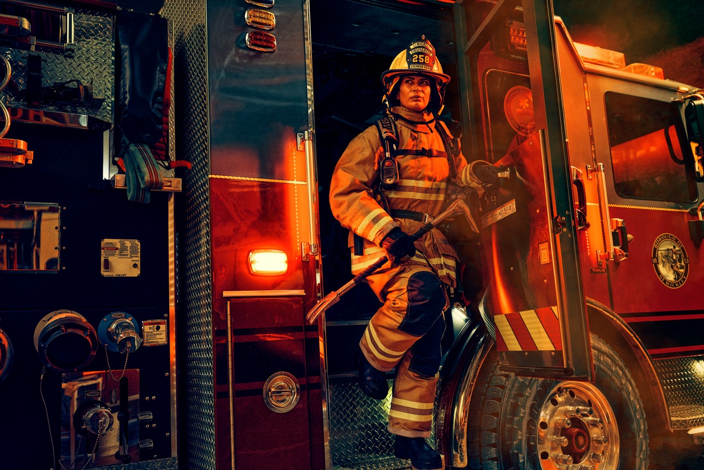 A firefighter exiting a fire truck in an emergency setting.