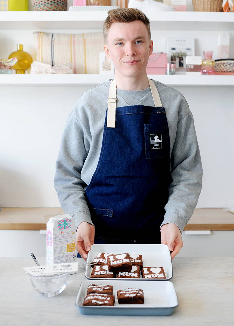 Jasper wearing an Edwin Louie Apron with his finished brownies