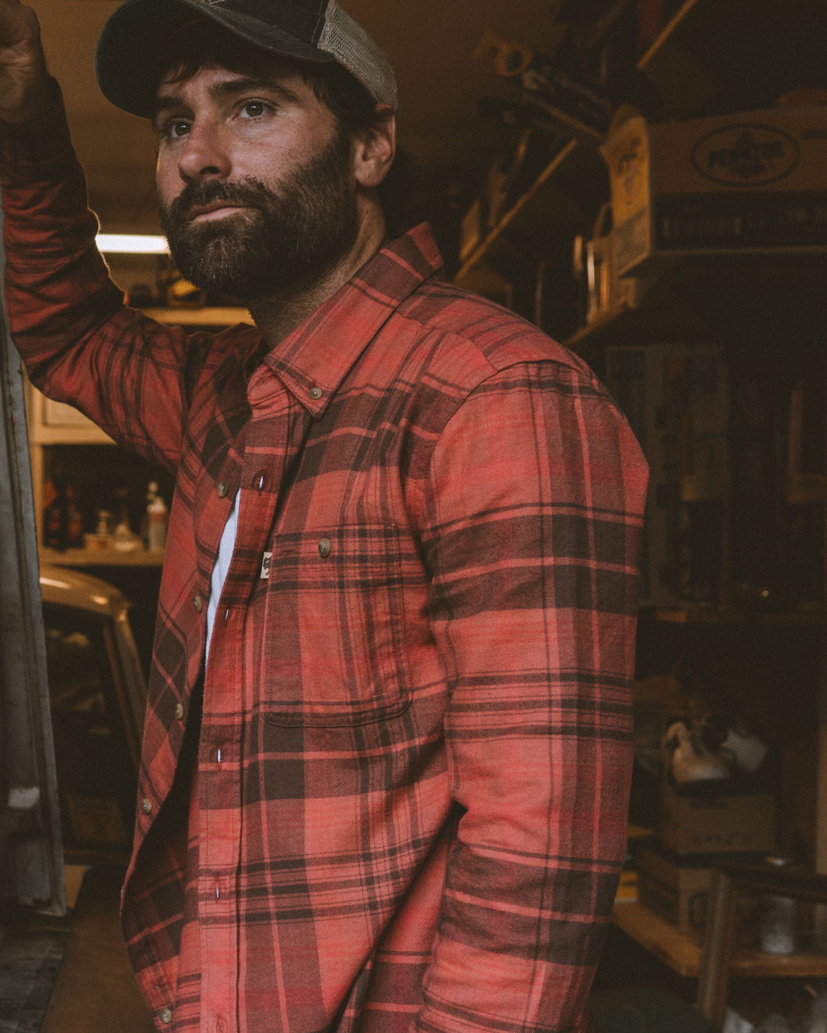Bearded man wearing a Buffalo Jackson red plaid flannel shirt in a rustic workshop