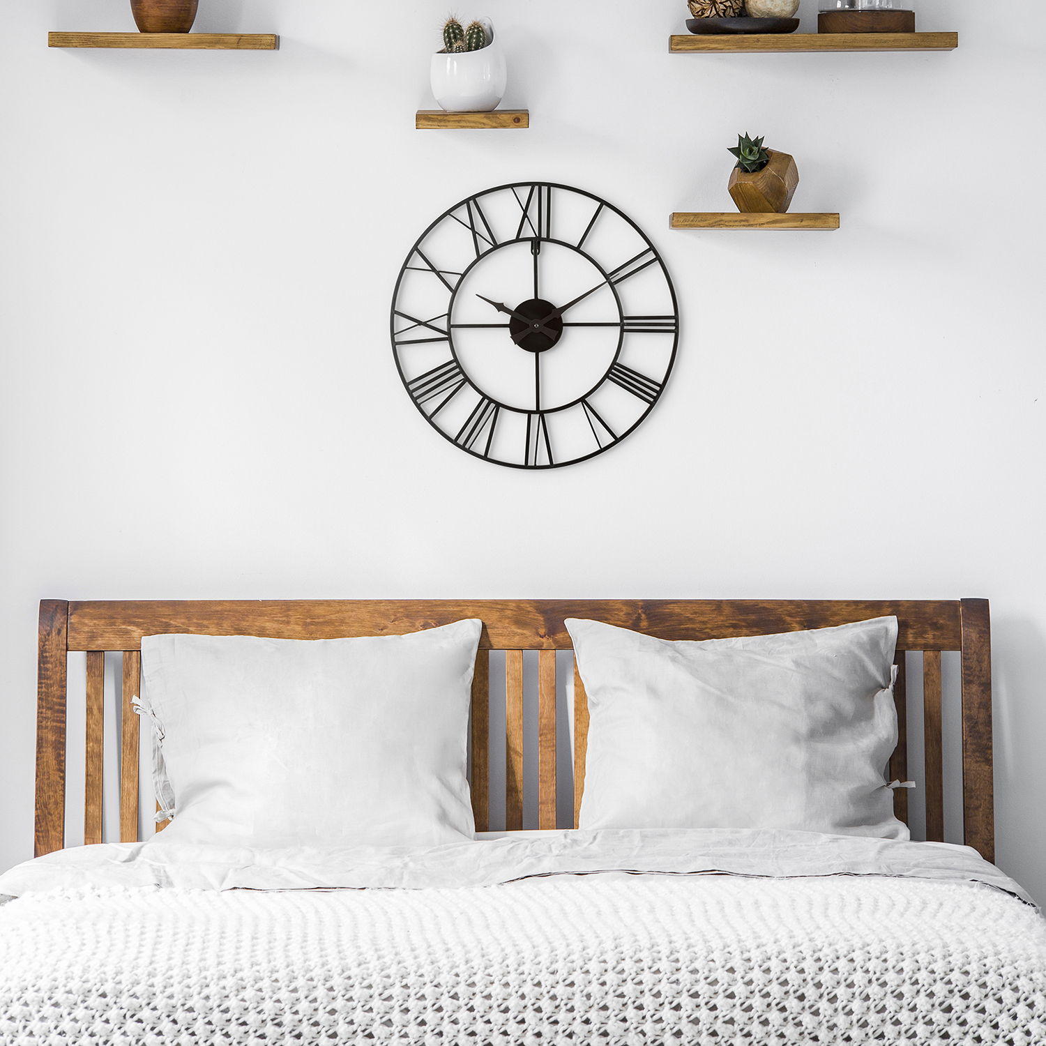 Cozy bedroom with a wooden bed and the 21-inch Skelton Tower Clock hanging on the wall 