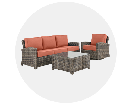 Outdoor furniture set with orange cushions, including a sofa, chair, and coffee table.