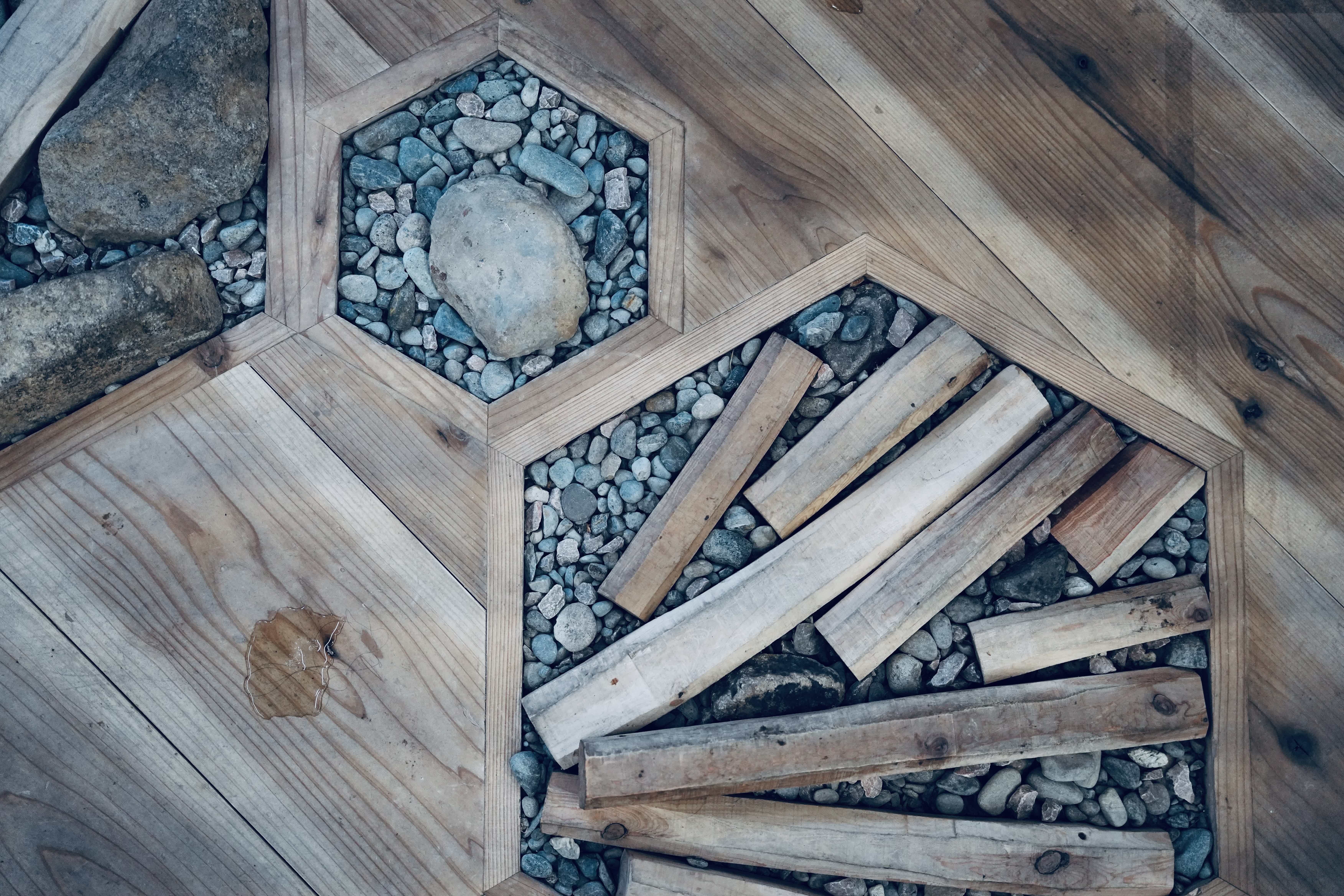 Hexagonal wood patterns with stones and logs embedded in the surface.