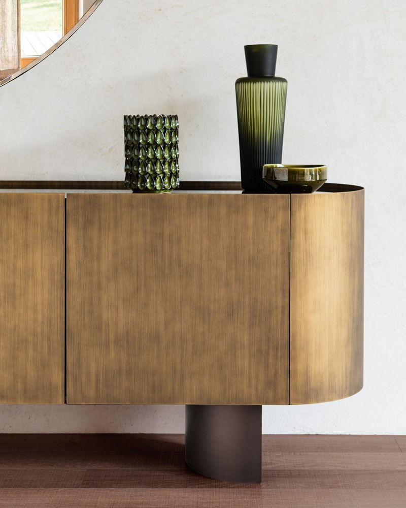 A decorative Cattelan Italia sideboard with vases and a round mirror.
