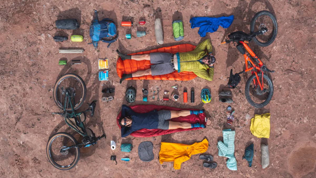 camping gear with sleeping bags, bottles, bikes, and other accessories