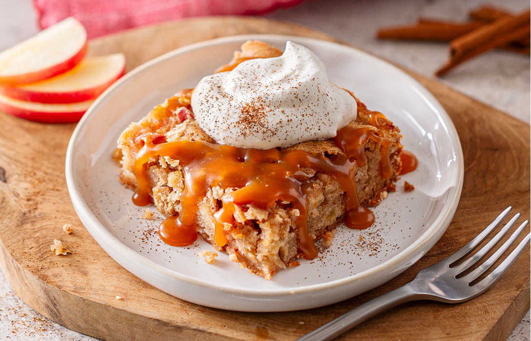 nana's apple cake slice on a plate with apples