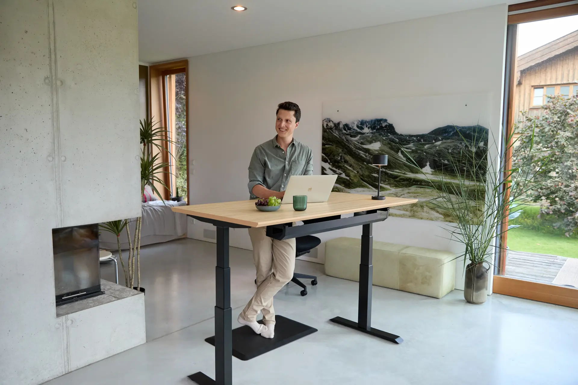 Christian Stiefel from ofinto is standing at a height-adjustable office desk Elevate in his home office