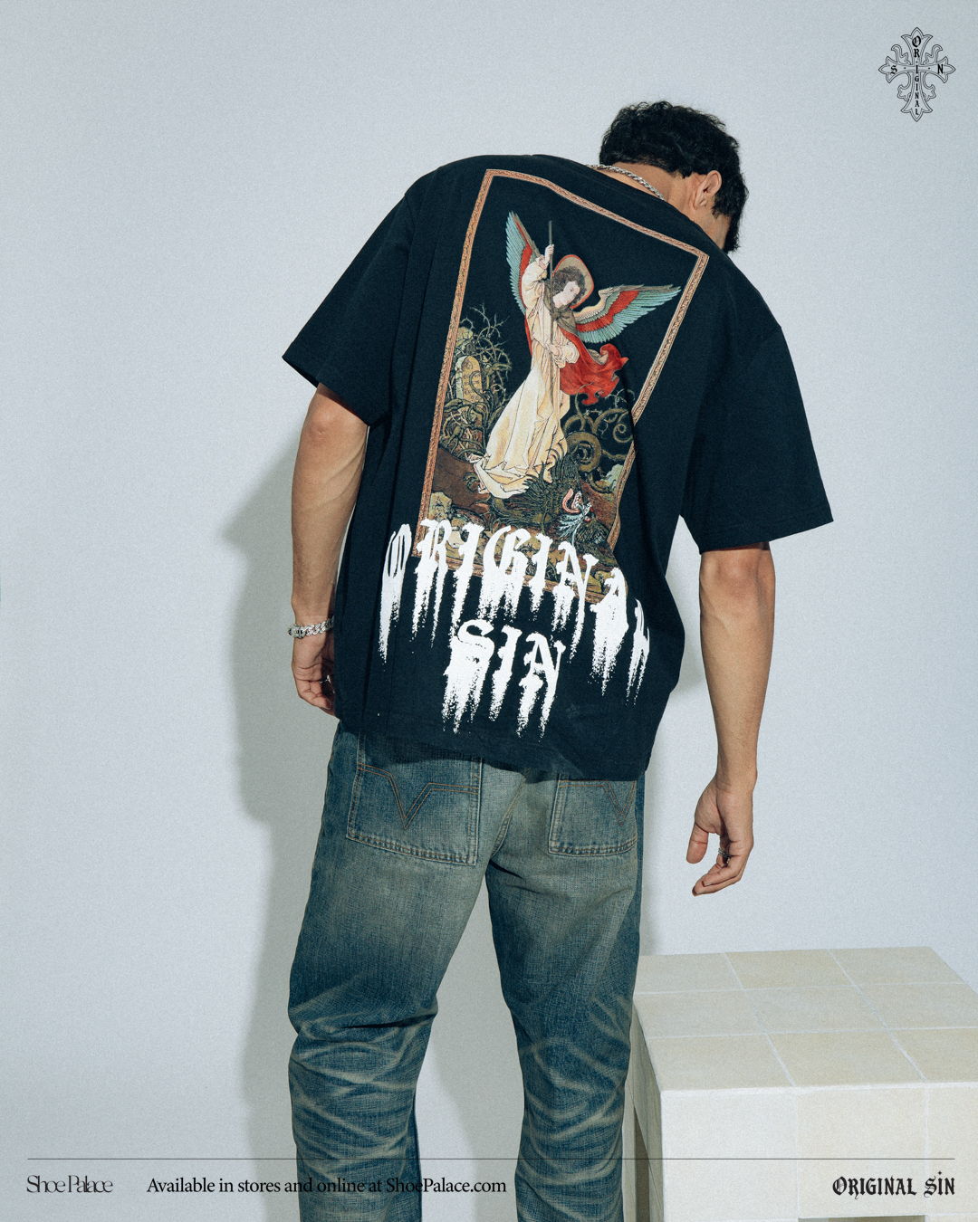 Person wearing a black t-shirt with an angel graphic on the back.