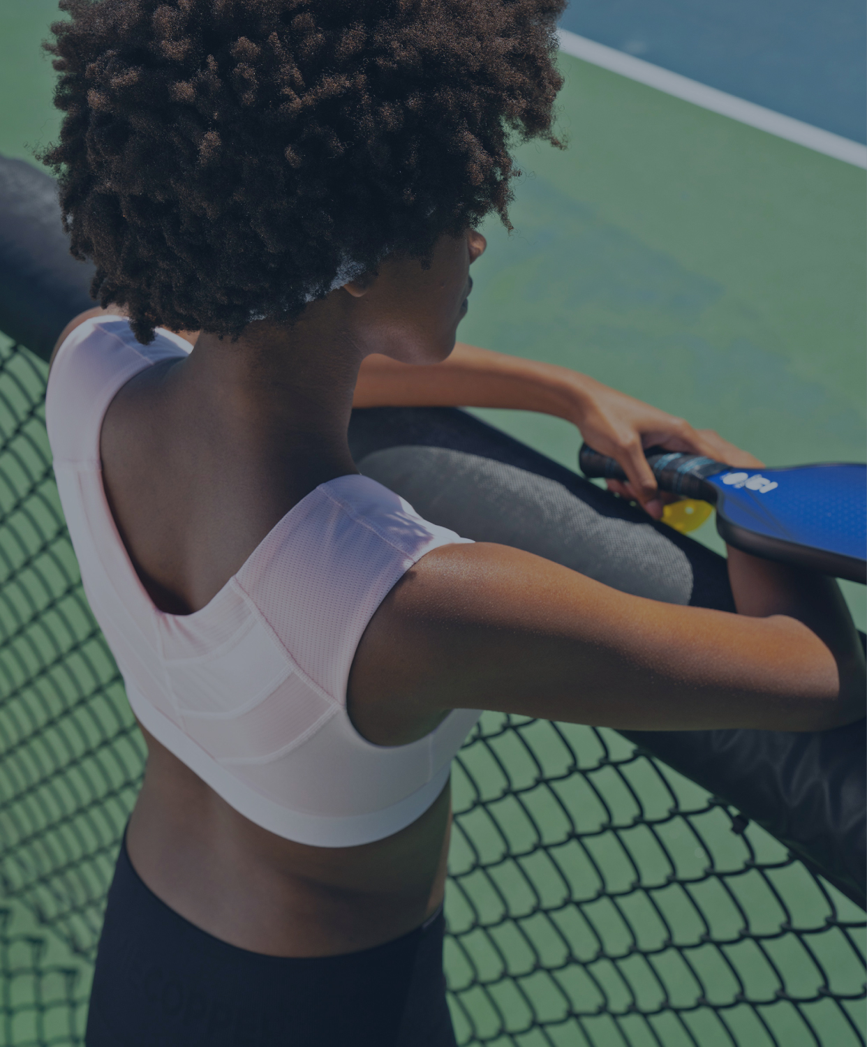 Woman wearing Zip Up Shoulder Support Bra preparing to play pickleball