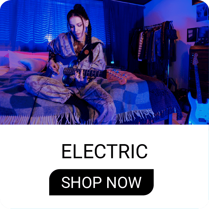 Person playing guitar on a bed with blue lighting.