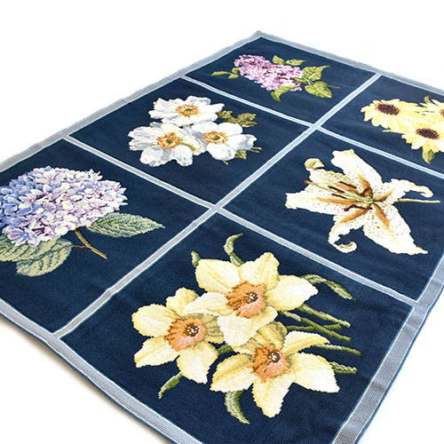 Six panel blooms rug with dark blue background and simple border